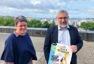 Un homme et une femme posent avec l'affiche de l'opération des Lieux à réinventer de la ville de Brest. 