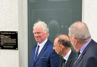 Des hommes devant une plaque d'hommage à un ancien combattant brestois