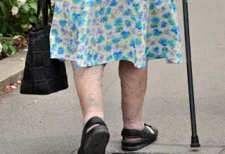 Une femme âgée marche dans la rue.