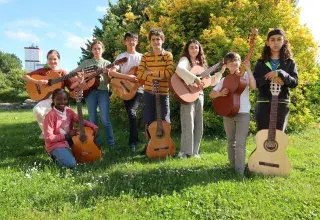 Photo montrant 5 jeunes guitaristes posant en extérieur dans un parc