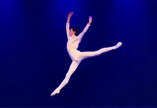 Photo montrant un jeune homme dansant sur une scène