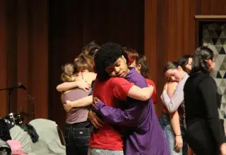 Photo montrant des étudiantes et étudiants se prenant dans les bras.