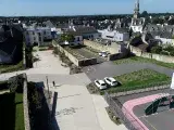 vue du dessus d'une église, un parking et une voie routière