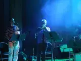 Photo montrant 1 saxophoniste et un trompettiste jouant en concert sur une scène